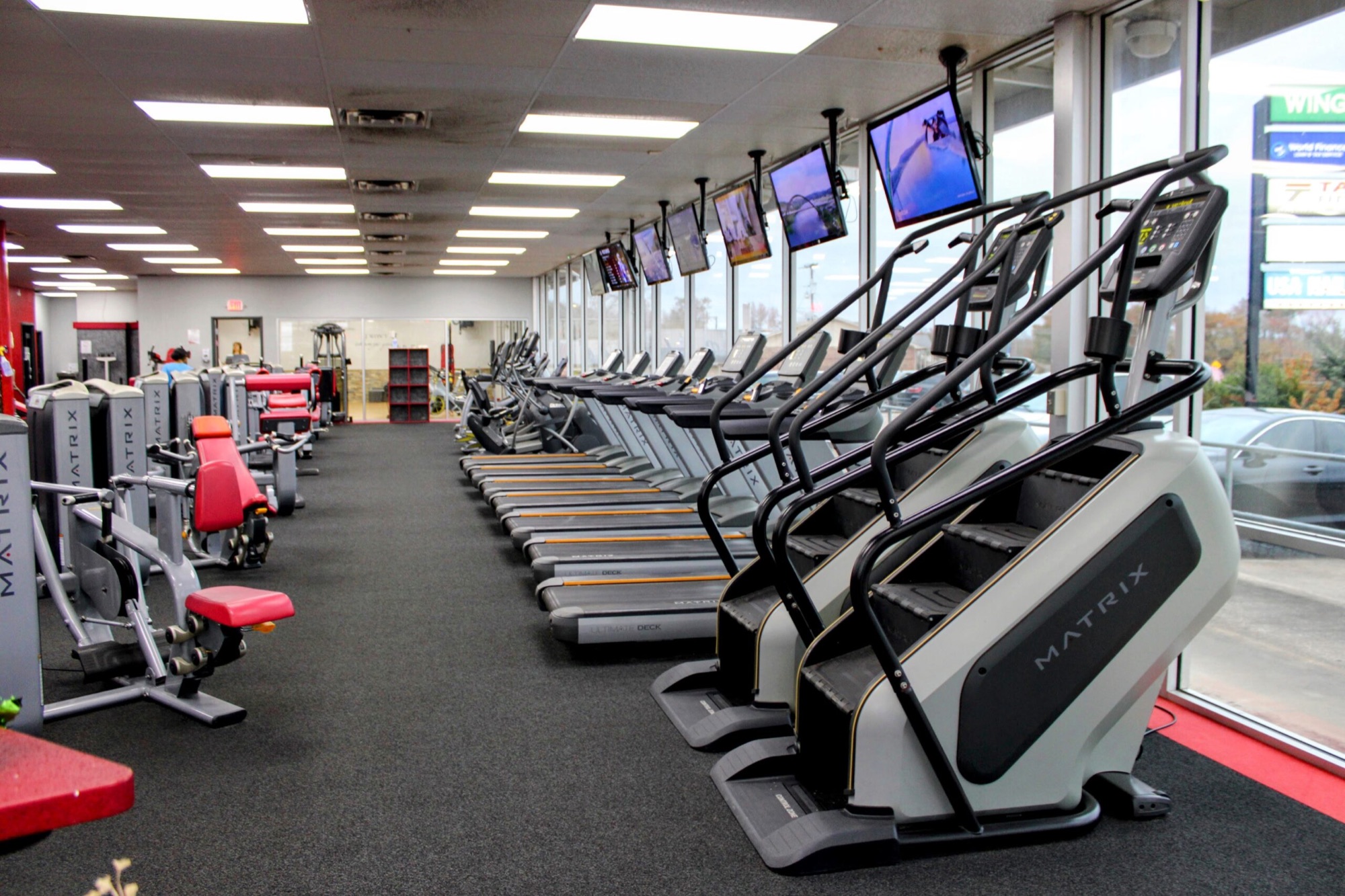 The gym floor at Taylor Fitness Palestine: strength machines, treadmills, and stair climbers